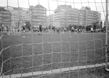 Imagem retrô em preto e branco da rede de um gol e um campo de futebol